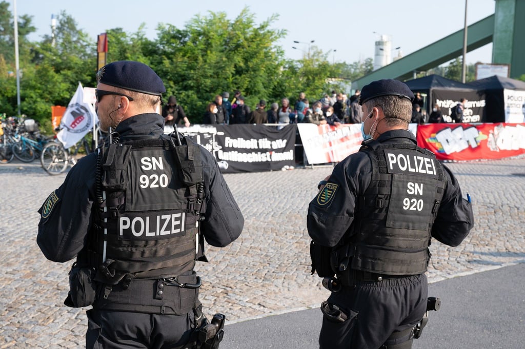 Polizisten stehen vor Beginn des Prozesses vor dem Oberlandesgericht Dresden Demonstranten gegenüber, die sich mit den Angeklagten solidarisieren.
