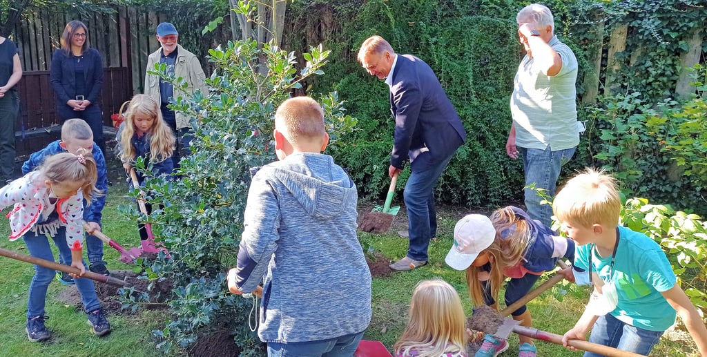 Den Baum des Jahres 2021 pflanzen Erstklässler und Gemeindebürgermeister auf das Schulgelände der Grundschule Möser.