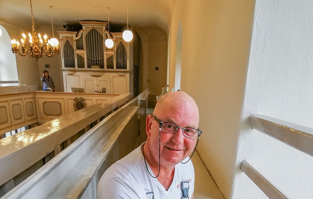 Malermeister  Michael Rothe streicht die letzten Bänke in der  Kirche Burtschütz.