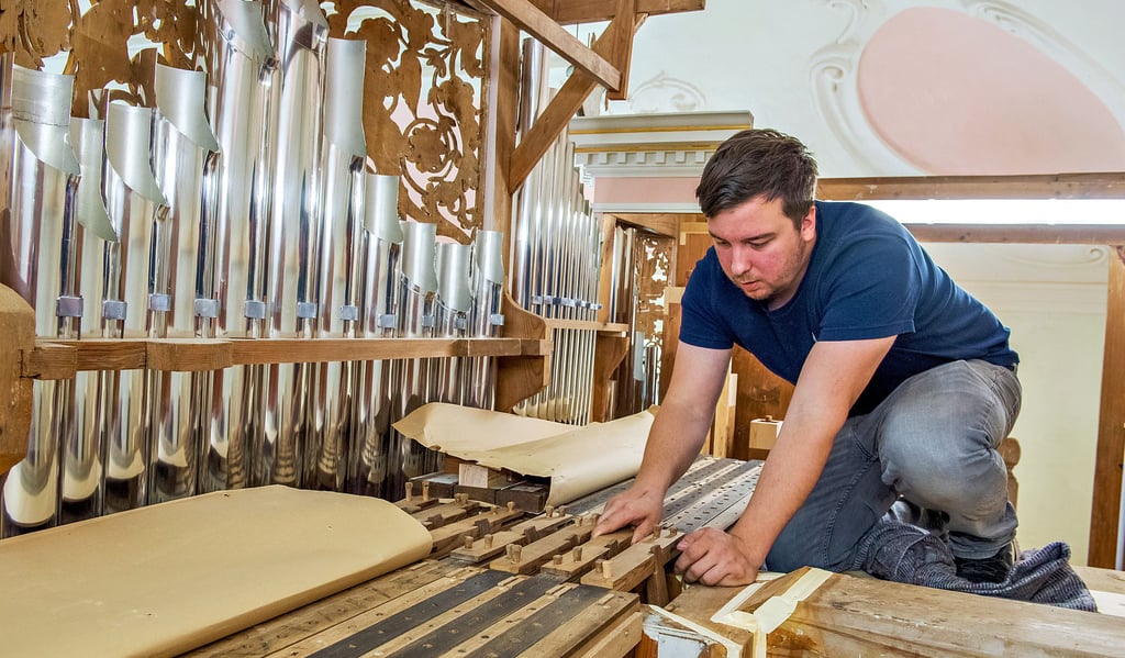 Die Zinnpfeifen blitzen, die Windlade ist gesetzt: Restaurator Lukas Koallick bei letzten Arbeiten an der Böhme-Orgel in Schönburgs Kirche.