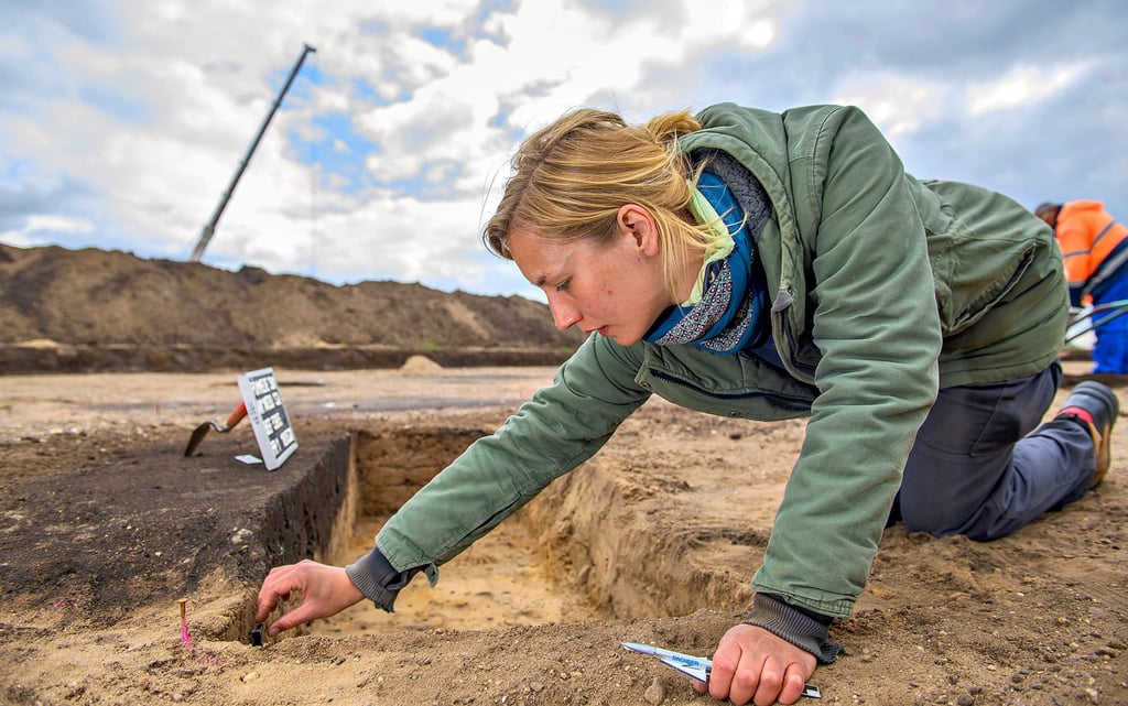Merle Scheunchen, stellvertretende Grabungsleiterin am Landesamt für Denkmalpflege und Archäologie, dokumentiert die Ausrichtung einer Abfallgrube.