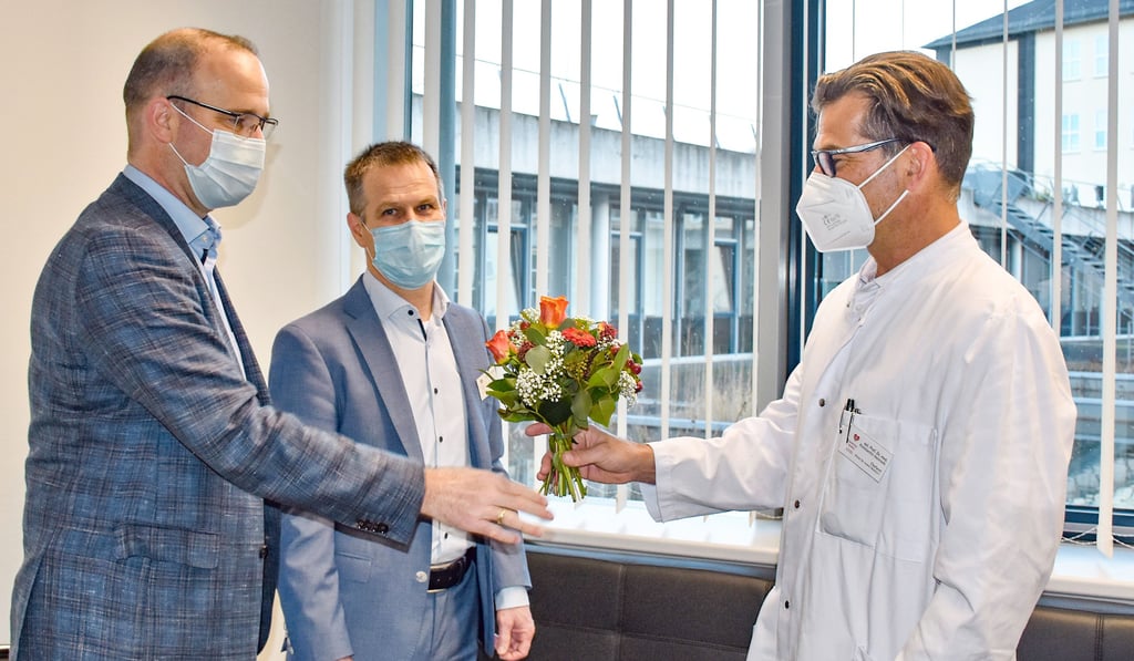 Die Krankenhaus-Geschäftsführer Pastor Markus Ebinger und Markus Füssel (v.l.) begrüßen den neuen Chefarzt Konstantin Heinroth an dessen ersten Arbeitstag mit Blumen und einem herzlichen Willkommen.