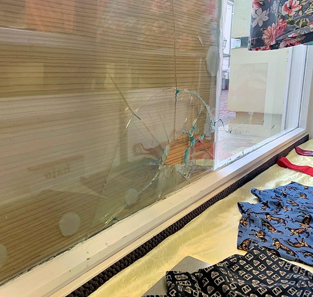 Marlies Göldner, Inhaberin von „Tendenz-Wäsche“ (oben), hat die kaputte Fensterscheibe mit einem Holzbrett verdeckt - zumindest von außen. Von innen ist das Loch, das durch einen Böller entstanden ist, noch zu sehen.