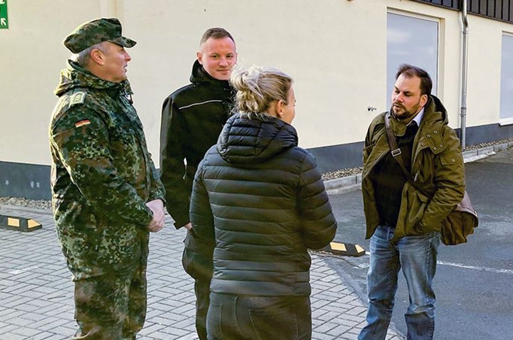 Mitarbeiter des Impfzentrums und des Wachdienstes warten nach Verlassen des Gebäudes auf die Ankunft der Sprengstoffspürhunde.