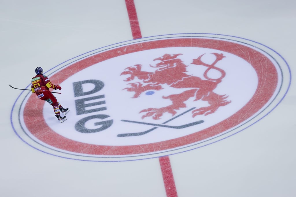 Ein Düsseldorfer Spieler fährt über das Logo der DEG auf dem Eis.