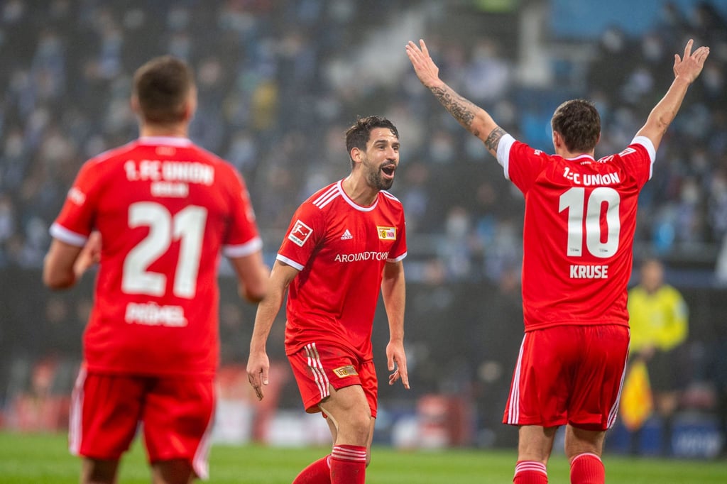 Unions Max Kruse (r) jubelt nach seinem Tor zur Berliner Führung mit Rani Khedira (M).