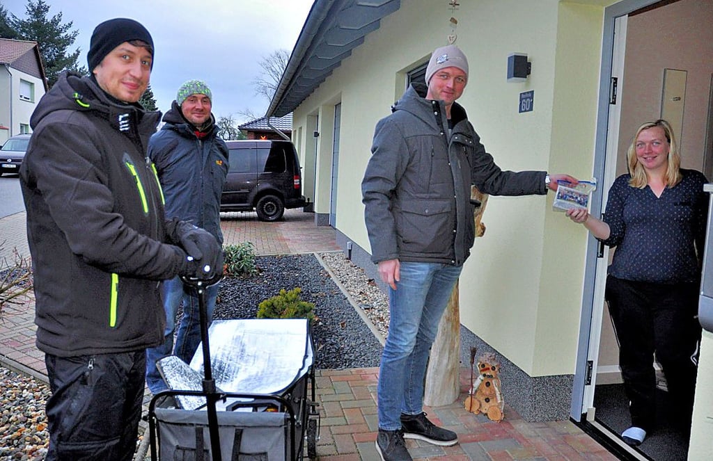 Claudia Weis (von rechts) nahm das Päckchen mit Neujahrsgrüßen von Christoph Lindecke, Michael Thiele und Christian Hietel entgegen. Die anderen Tüten wurden in die Briefkästen gesteckt.