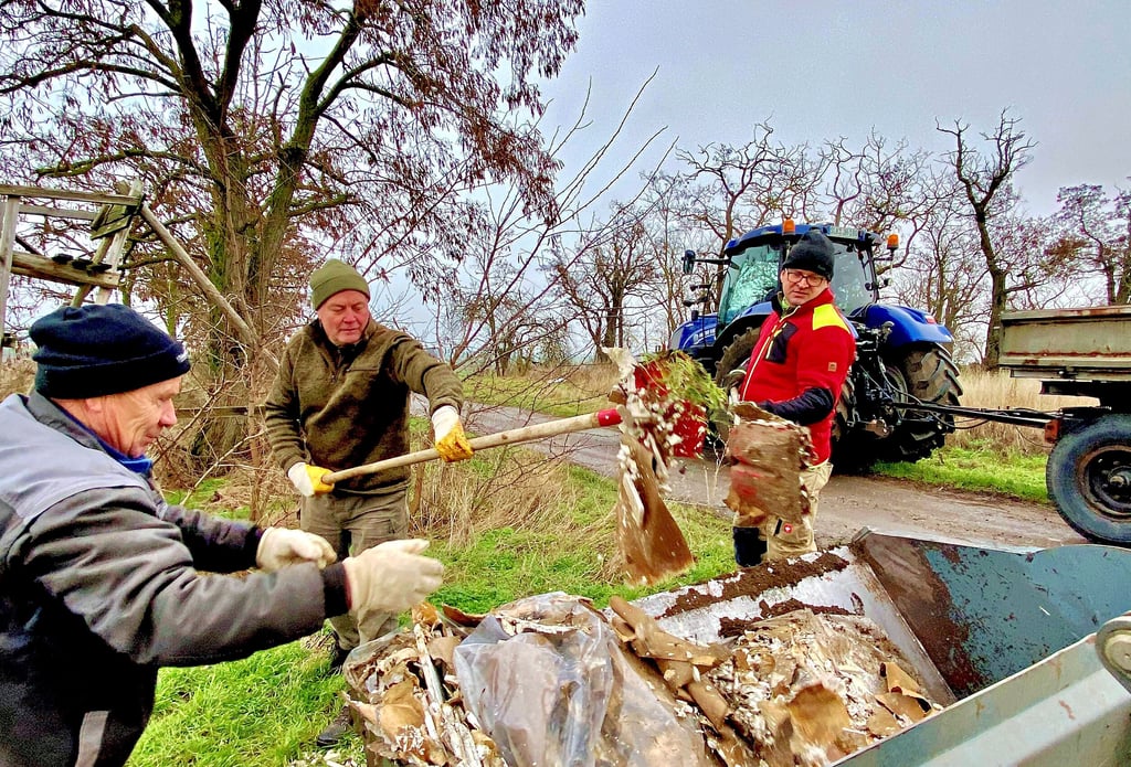 Frank Brach (v.l.), Michael Warthemann und Karsten Freyer laden den Müll auf den Radlader.
