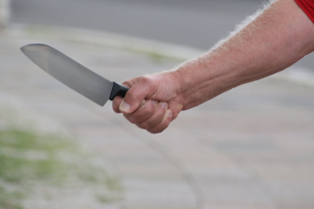 Ein Mann hält ein Küchenmesser in der Hand (Symbolbild)