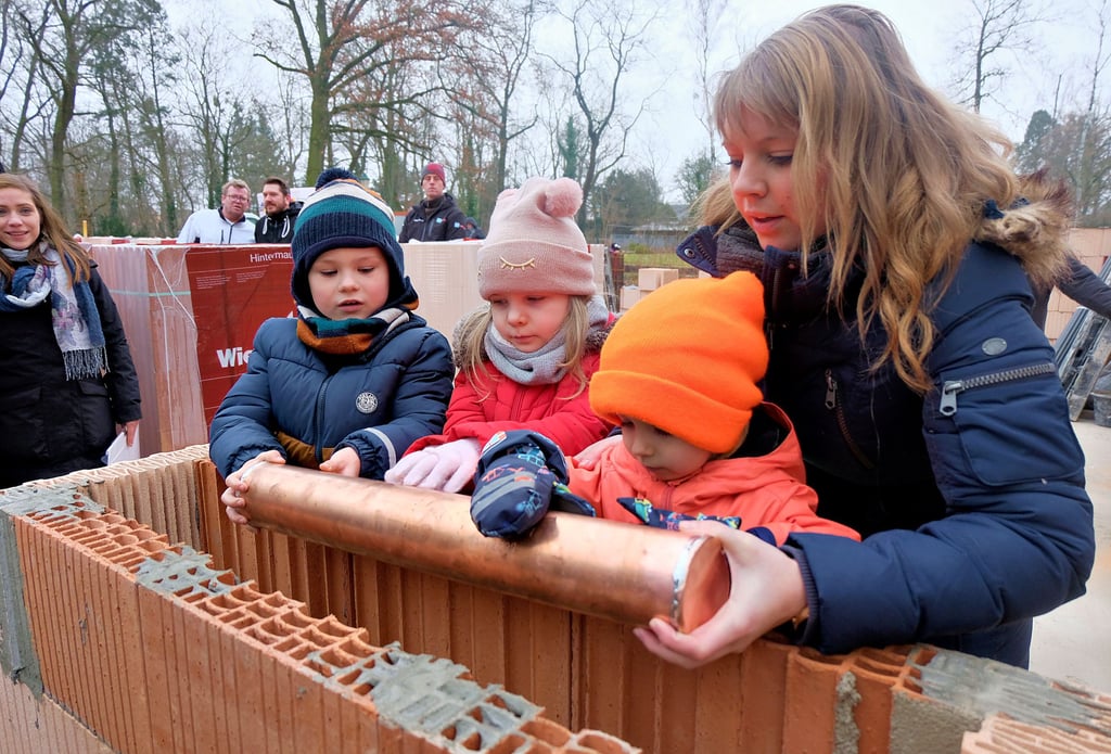 Kita-Chefin Svenja Wagner bringt mit Theo, Emelie und Henrik (von links) die gefüllte und verlötete Zeitkapsel ein.