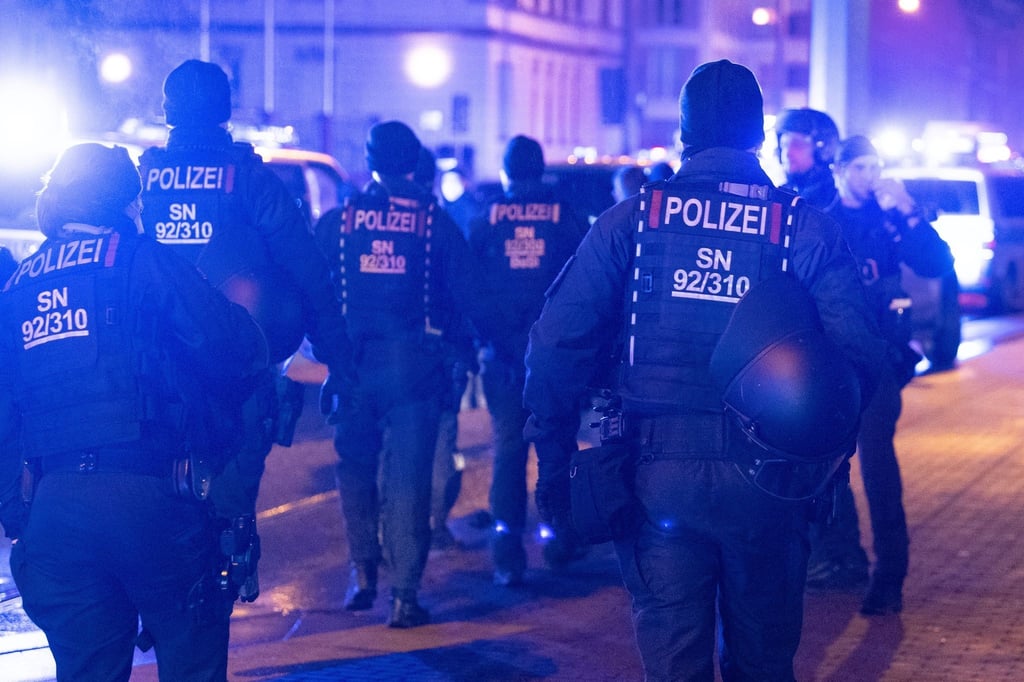 Polizisten stehen während eines Protest von Impfgegnern an einer Straße.