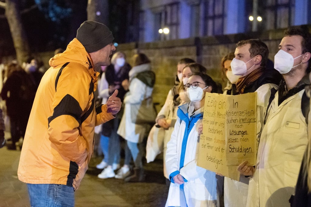 Ein Teilnehmer einer als „Spaziergang“ deklarierten Demo von Impfgegnern und Kritikern der Corona-Maßnahmen redet am Uni-Klinikum Dresden auf zahlreiche Gegendemonstranten ein.