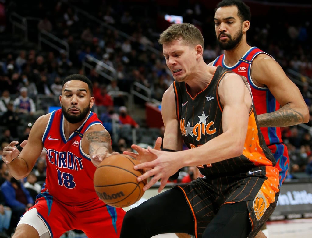Cory Joseph von den Pistons (l) stiehlt den Ball von Moritz Wagner von den Orlando Magic (M).