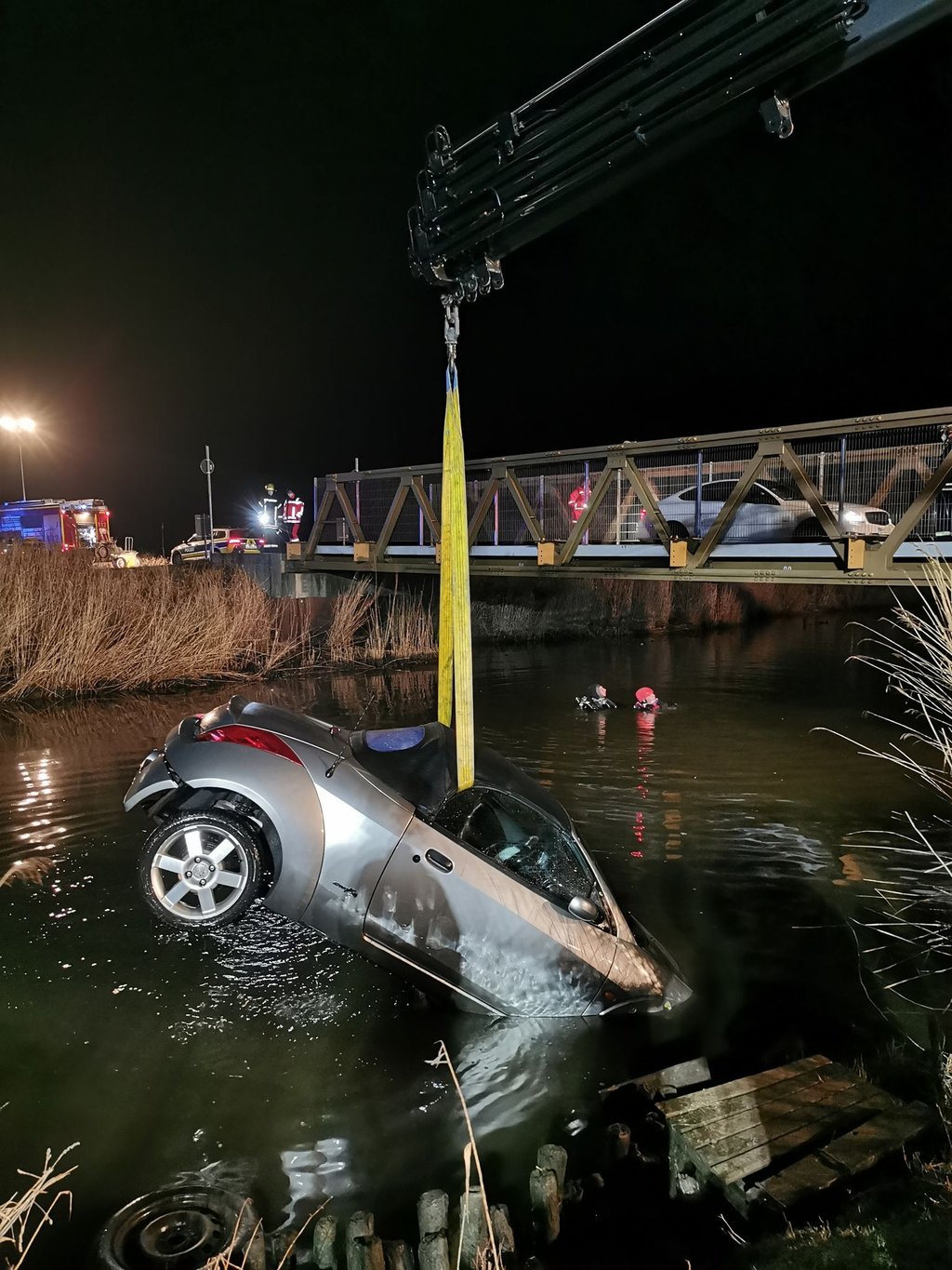 Taucher im Einsatz - eins der versunkenen Autos wird mit einem Kran geborgen.