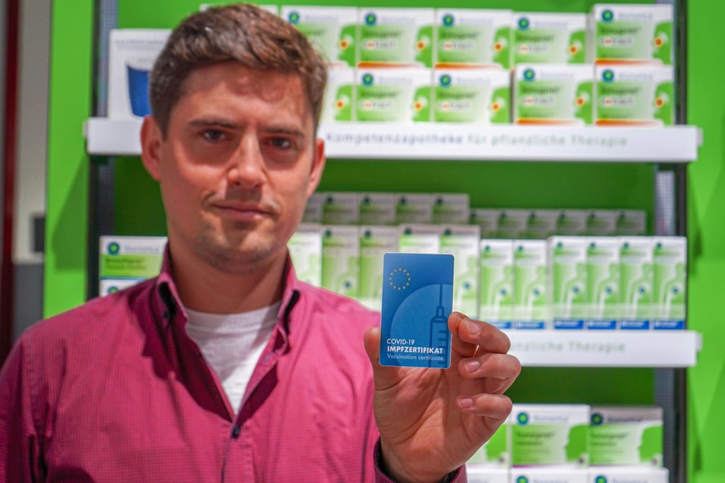 Martin Roschig, Mitinhaber der Raben-Apotheke, in Zerbst mit der Impfkarte im Checkkartenformat.