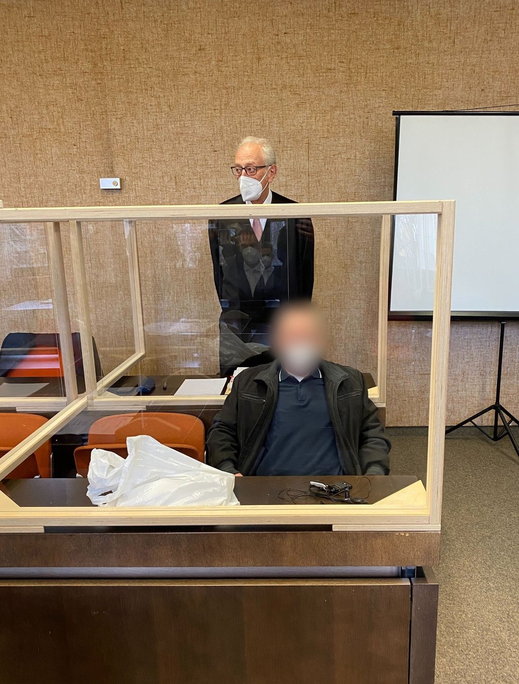 Der angeklagte Vater (vorne) zusammen mit seinem Anwalt (hinten) vor dem Prozess am Landgericht München I.