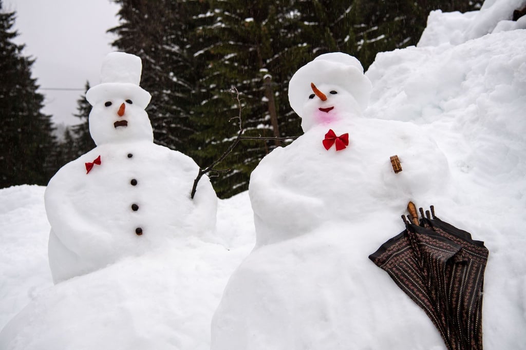 Vergänglich: Ein Schneemann und eine Schneefrau im Regen.