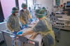 Ärzte und Pfleger untersuchen einen Patienten auf der Covid-19-Intensivstation. Der Triage-Fall ist bei der beginnenden Omikron-Welle nicht auszuschließen, sagt Ameos-Chef Axel Paeger.