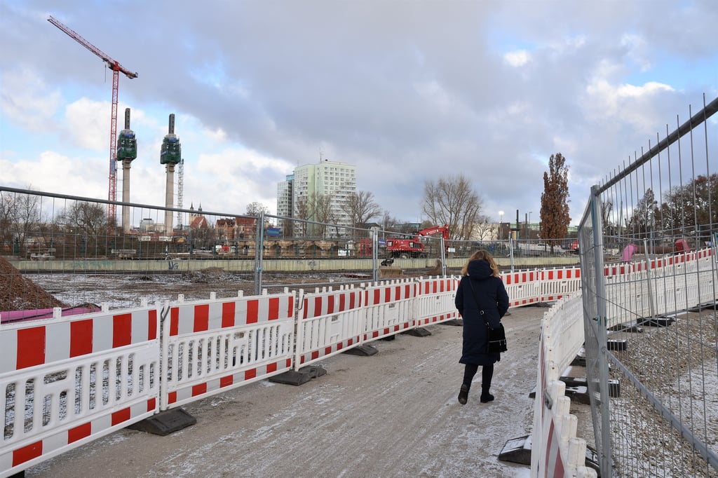 Mit Zäunen gesichert führt der provisorische Schotterweg einmal längs über die Großbaustelle am Heumarkt in Magdeburg.