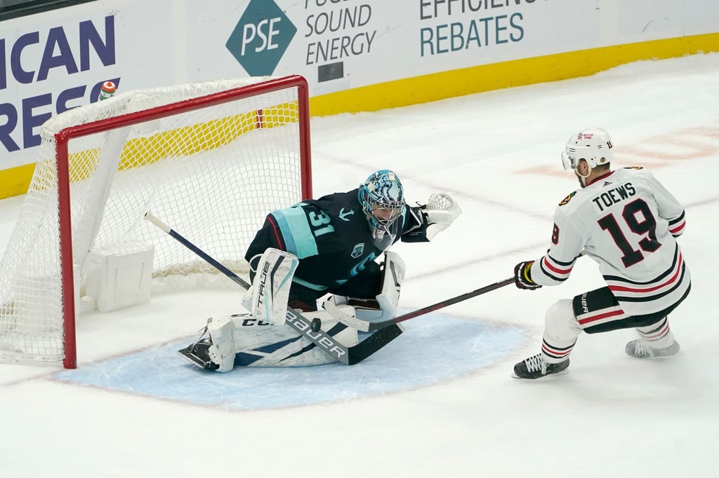 Kraken-Goalie Philipp Grubauer (l) pariert einen Schuss von Jonathan Toews.