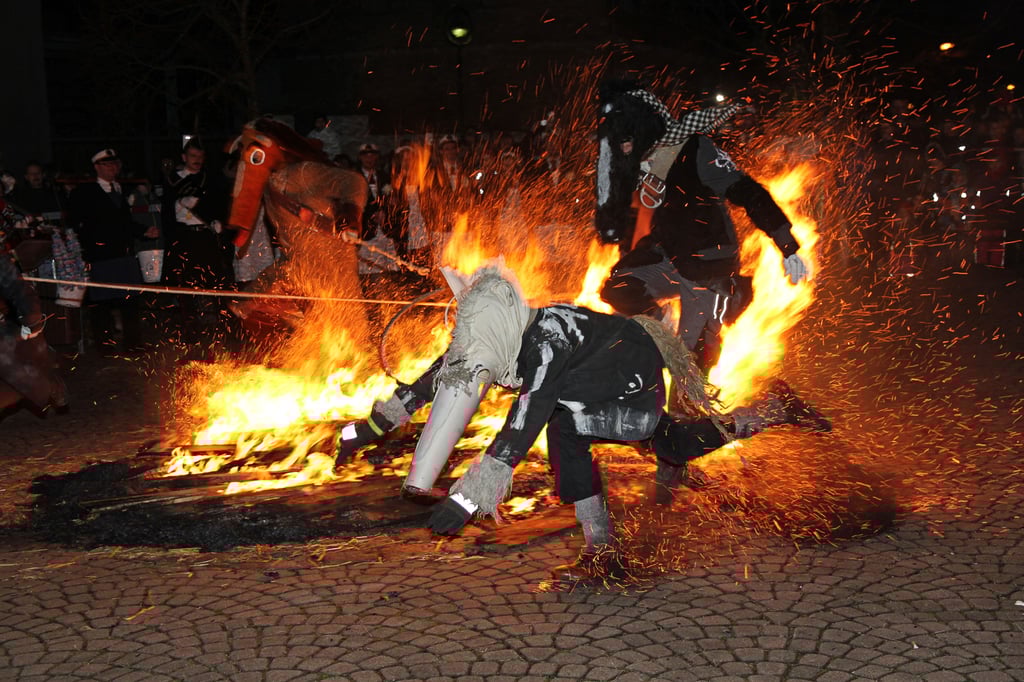 Pferde und Kutscher springen zur Lichtmeß am Bäckerplatz in Spergau durch das Feuer.