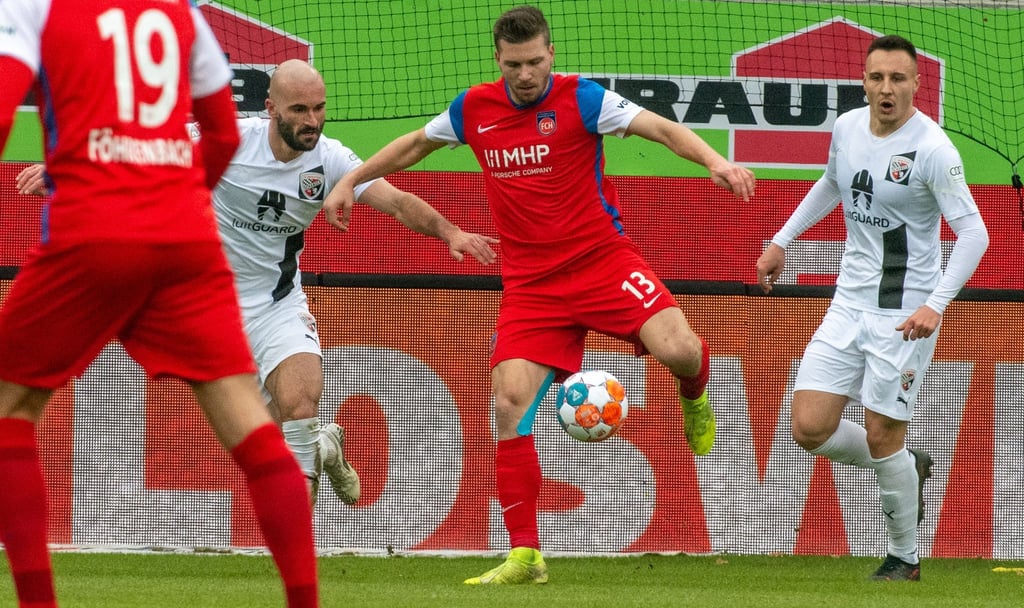 Heidenheims Robert Leipertz (M) behauptet den Ball gegen Nico Antonitsch (l) und Dominik Franke von Ingolstadt.