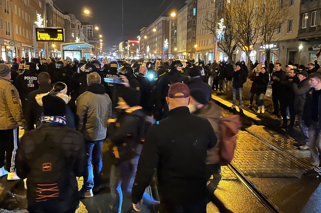 Polizisten in Schutzausrüstung stehen "Spaziergänger" in Magdeburg gegenüber. Am Abend hatten sich die Gruppe versammelt, um mit einem Marsch durch die Innenstadt gegen die Maßnahmen zur Eindämmung der Corona-Pandemie zu protestieren.