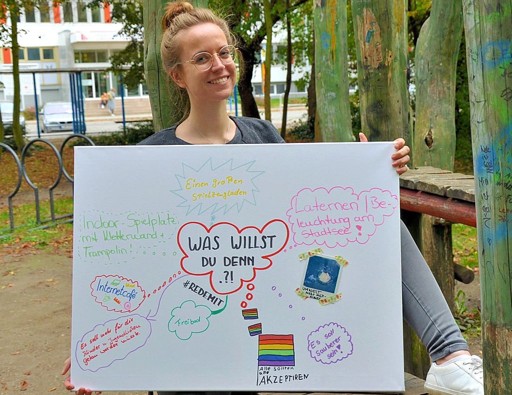 Janine Kaminski präsentiert auf einer Leinwand einige Wünsche der Kinder und Jugendlichen für Stendal.