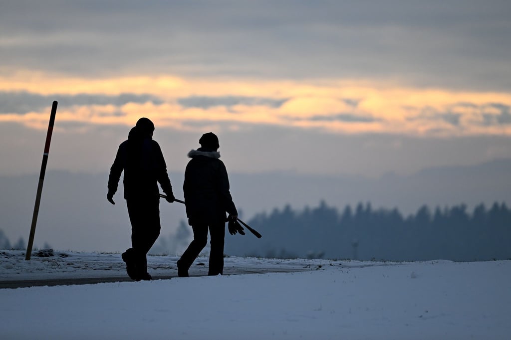 Morgendlicher Spaziergang kurz nach Sonnenaufgang auf einer schneebedeckten Anhöhe in Baden-Württemberg.