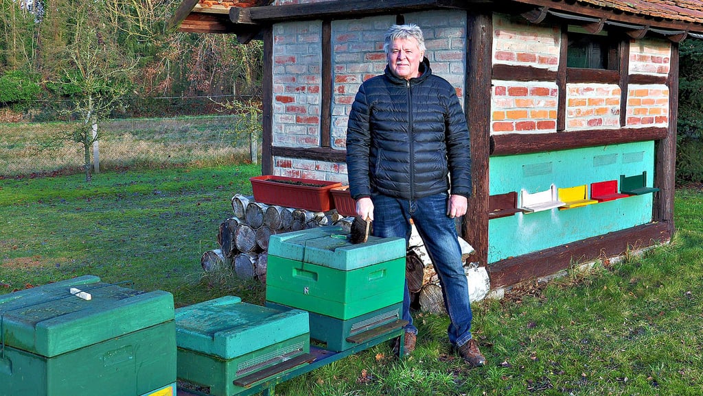Der Imker Stefan Tobehn steht vor sogenannten Zandern. Das sind die grünen Boxen, in denen die Honigbienen überwintern und sich zu einer Traube zusammenkuscheln, um nicht zu erfrieren.