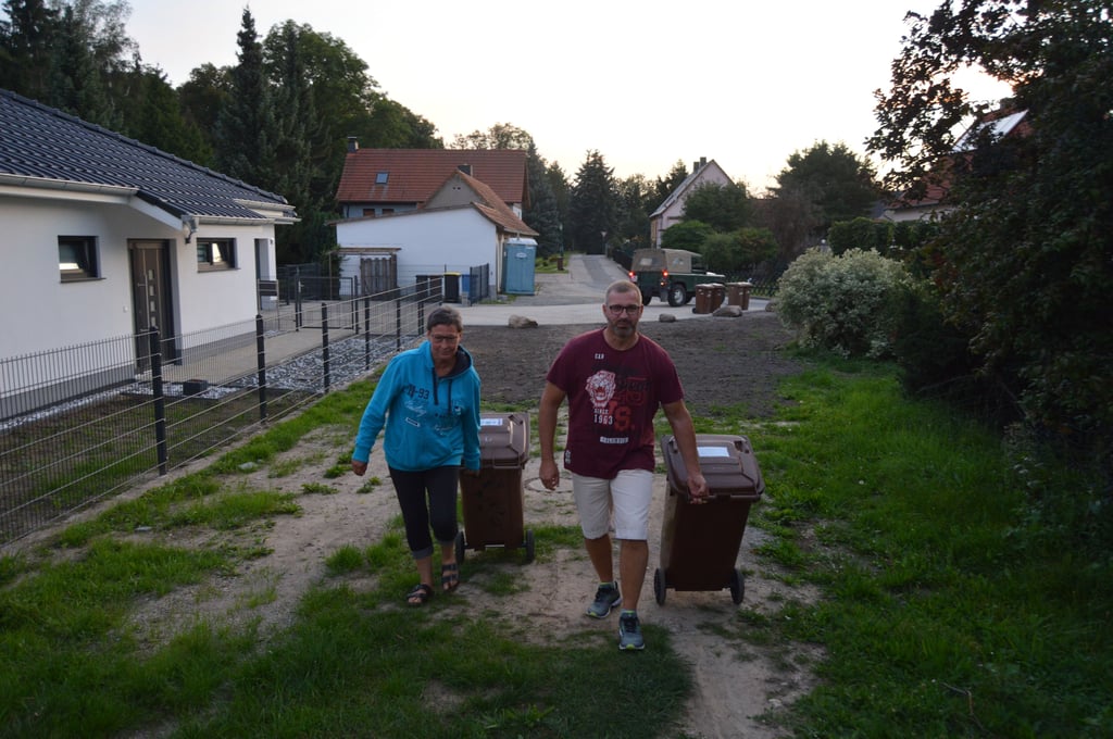 Anwohner wie Heike Walter und Steffen Becker müssen seit vergangenen Sommer Mülltonnen nun über Hang, Wiese und Acker zu einem Sammelplatz schleppen.