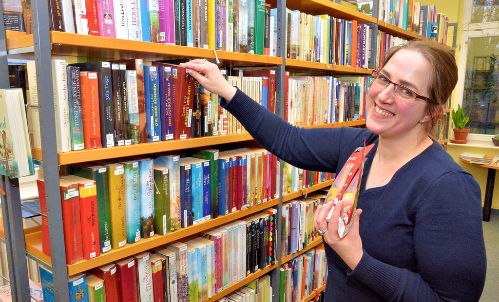 Bibliotheksleiterin Bianca Hochstein erläutert das Sortiment der Bücherei in Salzwedel. Noch nicht im Regal zu finden sind die Tonie-Hörbücher für Kinder, die sie in der Hand hält. Diese müssen erst noch im System erfasst werden. 