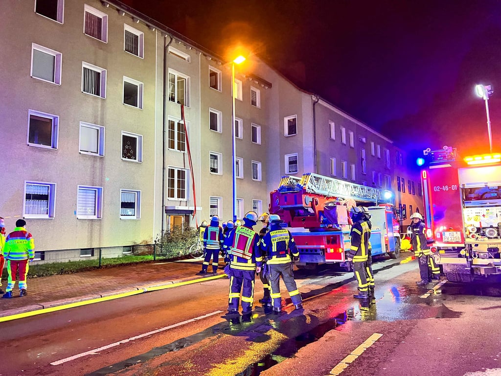 Die Einsatzkräfte der Feuerwehr vor dem Mehrfamilienhaus.