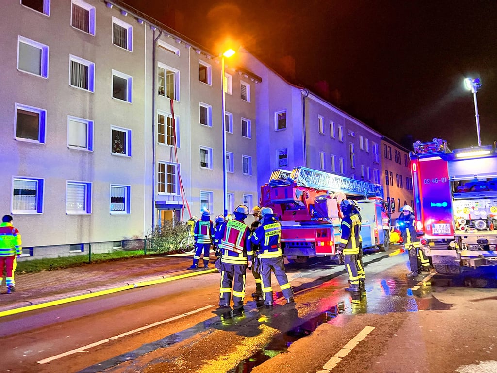 Die Einsatzkräfte der Feuerwehr vor dem Mehrfamilienhaus.