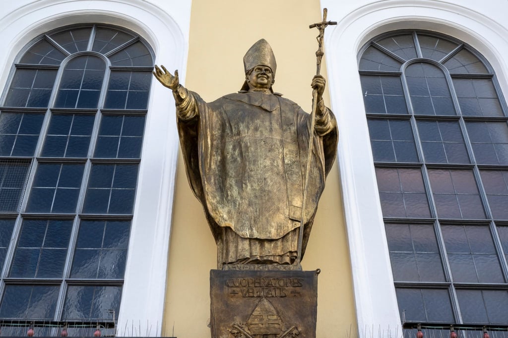 Eine Figur des emeritierten Papstes Benedikt XVI. an einer Fassade in Altötting.