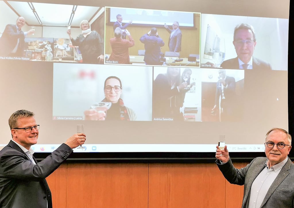 Der Rheiner Bürgermeister Peter Lüttmann (links) und Reiner Wellmann, Vorsitzender des Rheiner Städtepartnerschaftsvereins, stoßen auf die neue Internetseite der Partnerstädte mit einem Glas Sekt an.