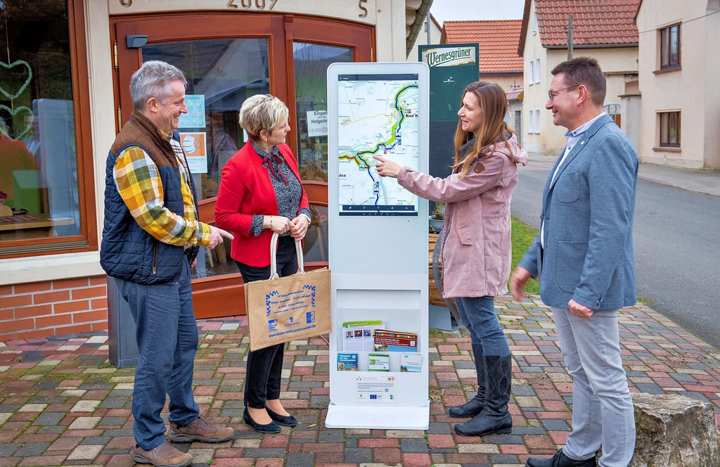 Steffi Einecke und Udo Mänicke (r.) von der lokalen Leader-Aktionsgruppe Saale-Unstrut-Triasland übergeben das digitale Informationsdisplay an Steffen und Grit Sonnekalb.