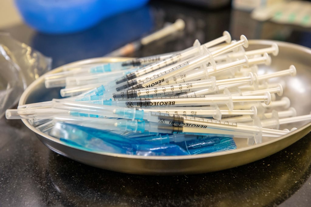 In einer Schale liegen leere und noch unbenutzte Spritzen, die zum Verimpfen des mRNA-Impfstoff von Moderna.