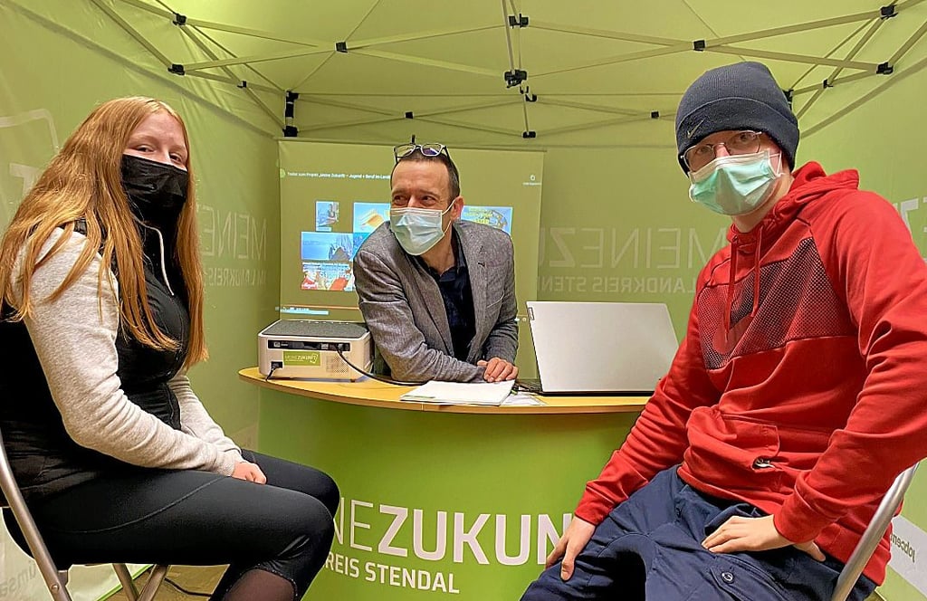 Ashley Engel (links) und Tyron Hamann (rechts) lassen sich im Pop-up-Office in Stendal von Edward Turner beraten.