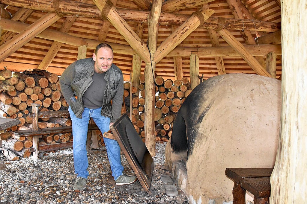Wilko Florstedt vom Förderverein des Steinzeitdorfes zeigt den großen Backofen im Museum. Dieser hat unlängst eine neue Überdachung mit Platz für eine ganze Schulklasse erhalten.