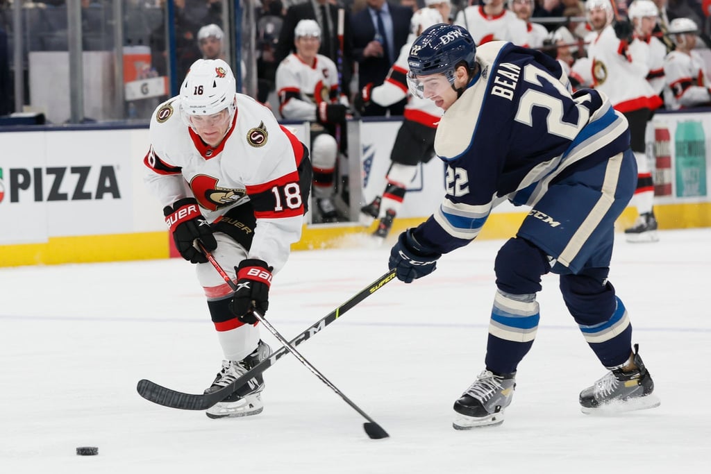 Tim Stützle (l) von den Ottawa Senators kämpft mit Jake Bean von den Columbus Blue Jackets um den Puck.