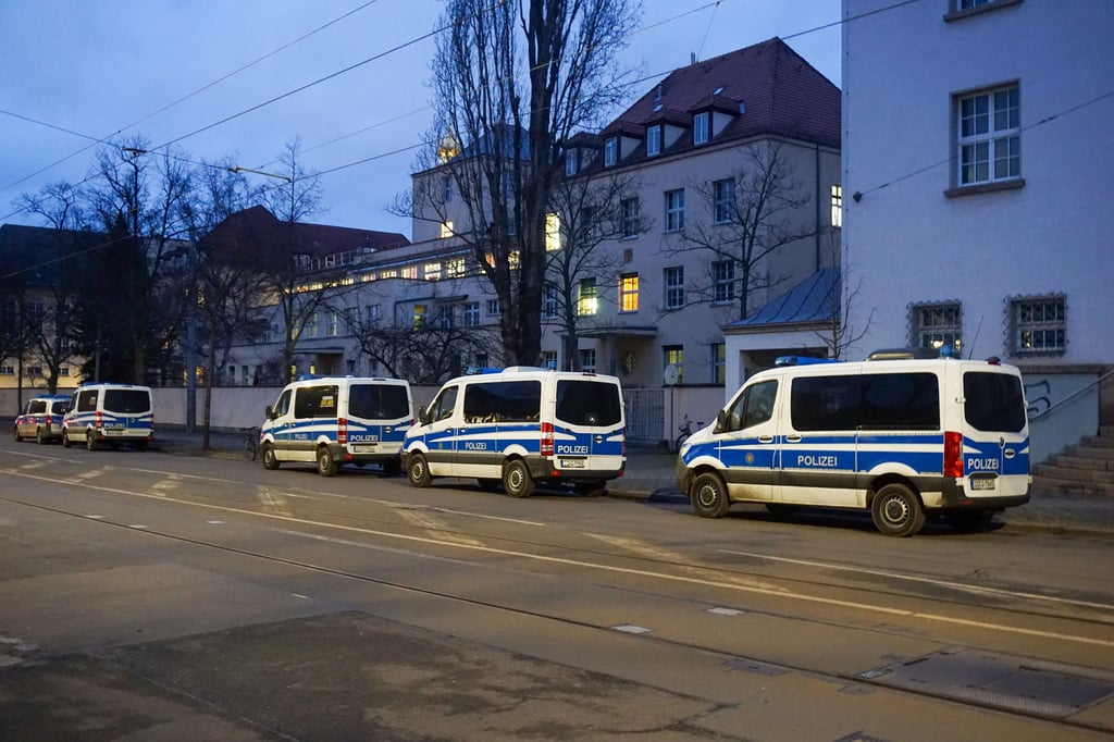 Einsatzfahrzeuge der Polizei stehen vor dem Gelände der Psychiatrie der Uniklinik Leipzig.