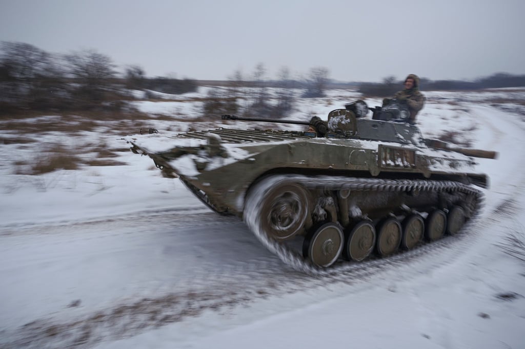 Ukrainische Soldaten fahren mit einem gepanzerten Mannschaftstransportwagen durch den Schnee.