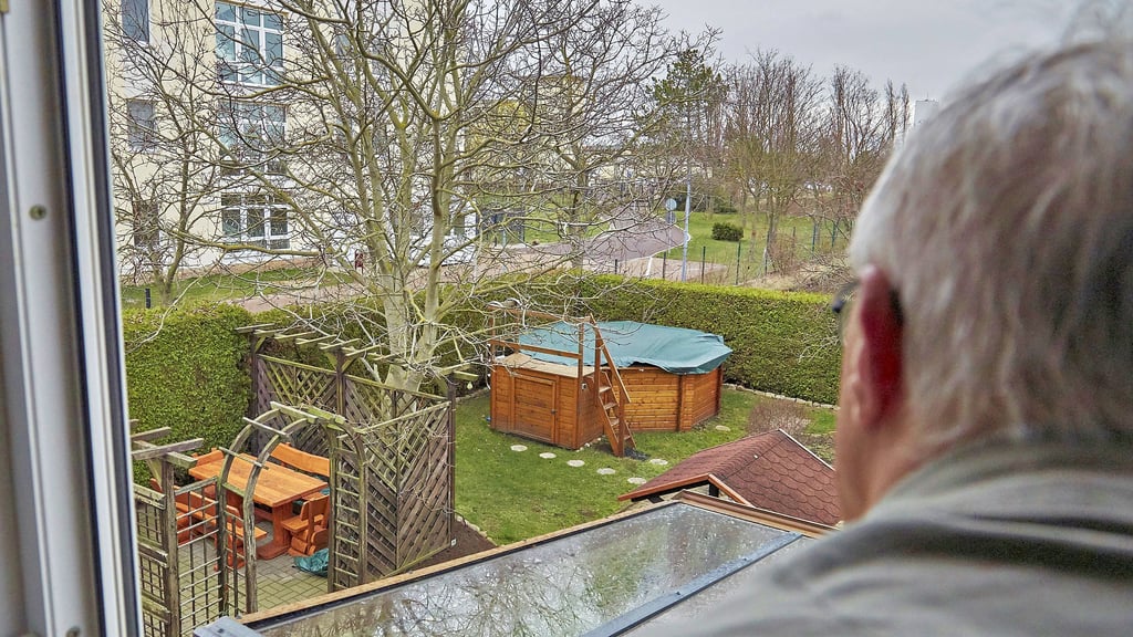 Gerhard Warthemann blickt aus dem Fenster seines Hauses direkt auf die Flüchtlingsunterkunft, deren umzäunter Aufenthaltsbereich direkt an sein Grundstück grenzt.