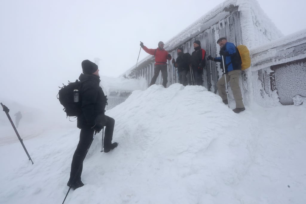 Wanderer sind bei Nebel auf dem Brocken unterwegs. Starker Wind und frostige Temperaturen haben eine bizarre Winterlandschaft hinterlassen.
