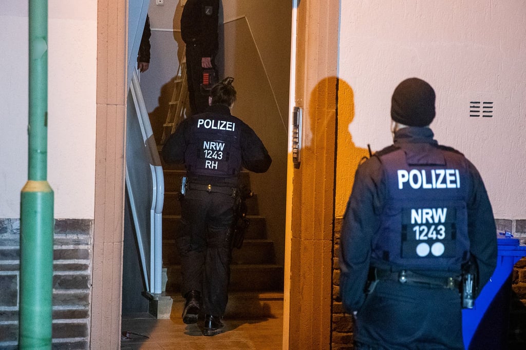 Einsatzkräfte der Polizei durchsuchen ein Mehrfamilienhaus in Essen.