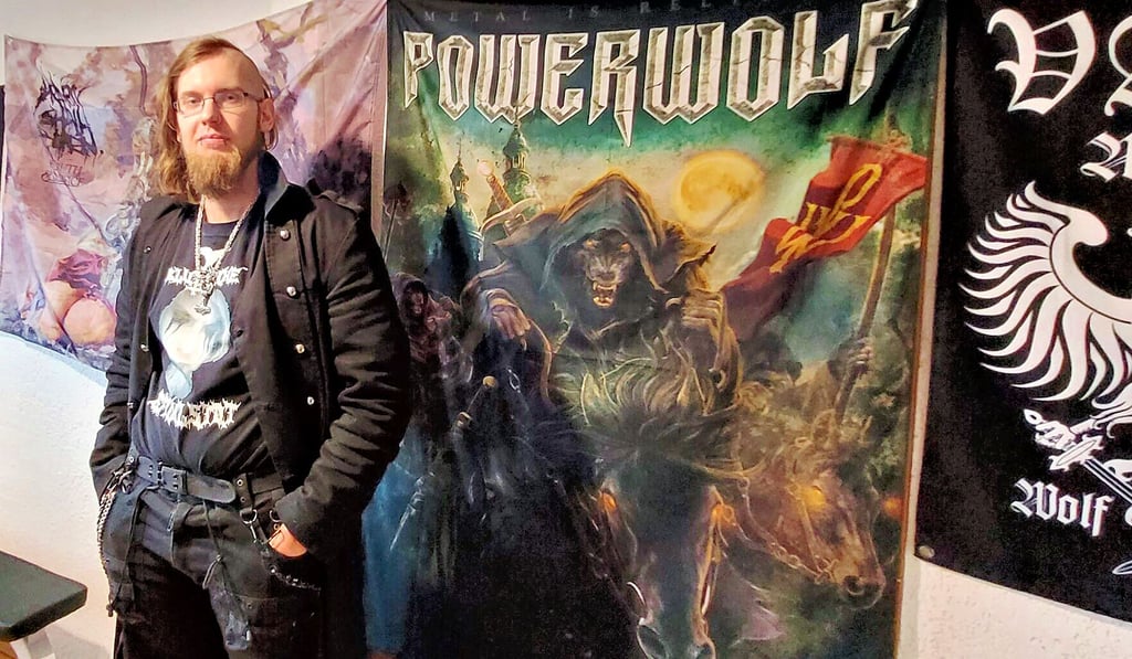 Patrick Kranig vor seiner Fahnenwand in der heimischen Küche. Die Band „Powerwolf" gehört mit zu seinen Lieblingsbands.
