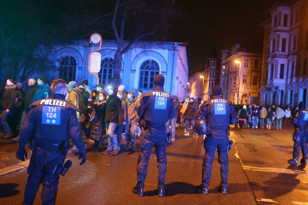 Teilnehmer einer Demonstration gegen die Corona-Maßnahmen gehen durch die Innenstadt von Gera und werden von der Polizei begleitet.