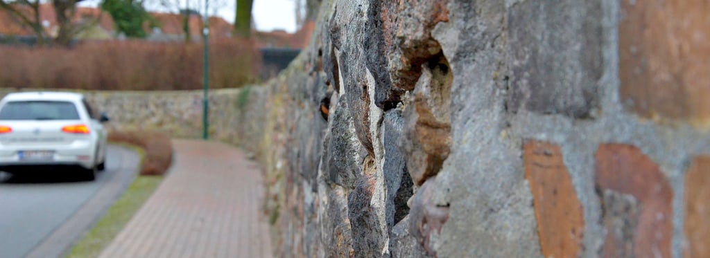 Die Kirchhofmauer an der St.-Georg-Kirche Salzwedel neigt sich teilweise in Richtung Gehweg. Sie soll in diesem Jahr saniert werden.