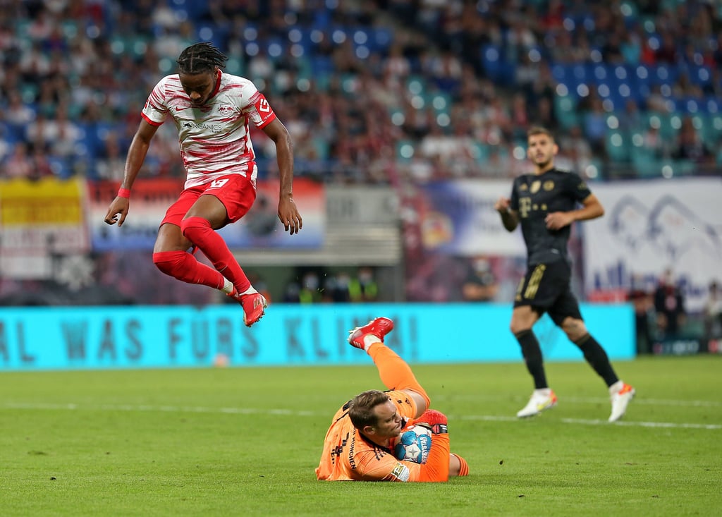 Christopher Nkunku (RB Leipzig) überspring Bayern-Schlussmann Manuel Neuer.
